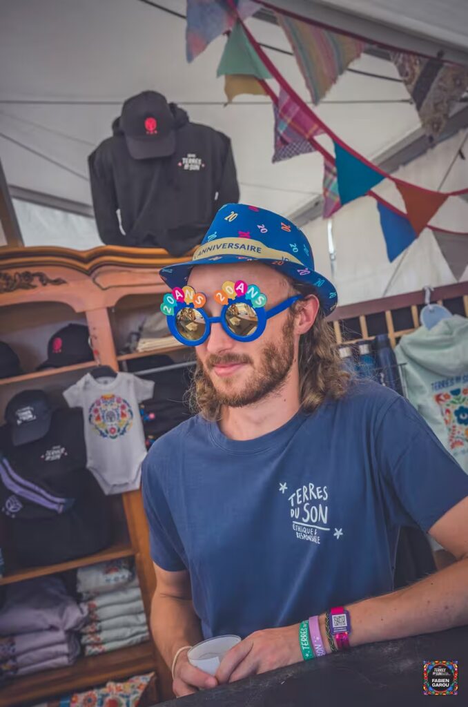 Un bénévole au merch porte des lunettes fantaisistes des 20 ans