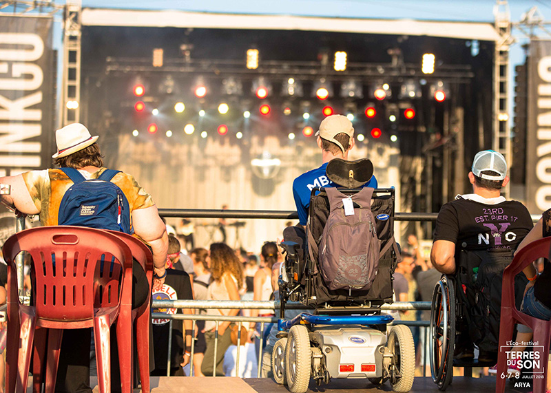 Des personnes en fauteuil roulant devant la scène