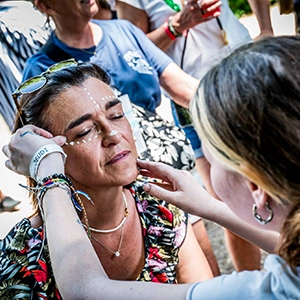 Une femme se fait maquiller à un stand de l'éco village